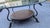 A contemporary coffee table by LaBarge, circa 1990s. Features a pencil polished glass top over a swooping iron base with...
