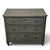 A classic Gustavian-style chest of drawers in grey. A decorative toothed trim sits beneath the top. The corners are...