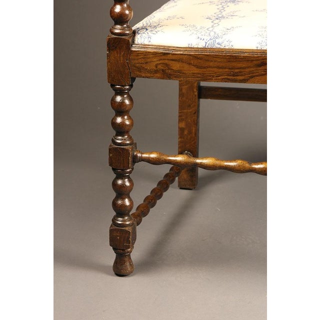 Elegant pair of antique English Jacobean style armchairs, dating to circa 1890, crafted in oak and featuring finely carved...