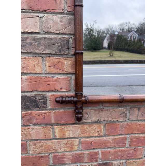 This is a French antique faux-bamboo wall mirror with a hand-carved wood frame. The frame is wood that has been shaped and...