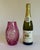 A striking cranberry-pink cased-glass vase featuring deeply cut geometric decoration that reveals the clear glass beneath....