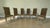A striking set of six mid-20th-century dining side chairs in the Neoclassical Directoire style, featuring tall, gently...