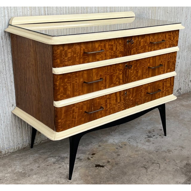 Commode or chest of drawers with three drawers and crest . Are made of wood and veneer and finished with cream lacquered...
