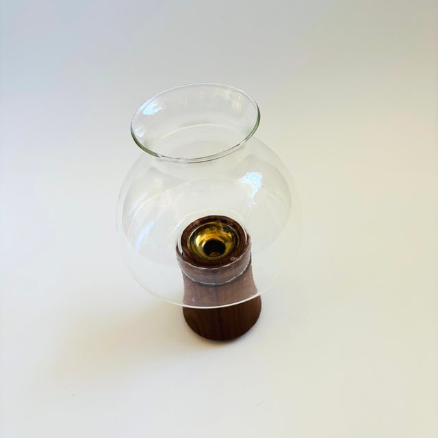 A mid century glass and teak candle holder by Dansk. Features a glass top that sits within a teak base. The base includes...