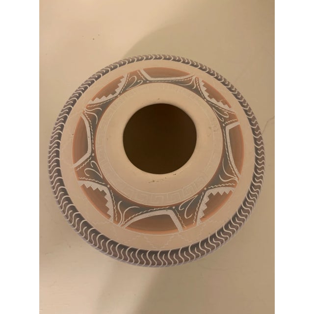 A beautiful vintage hand carved Southwestern pottery vase. Lovely pink and gray glaze over a white base color and a highly...