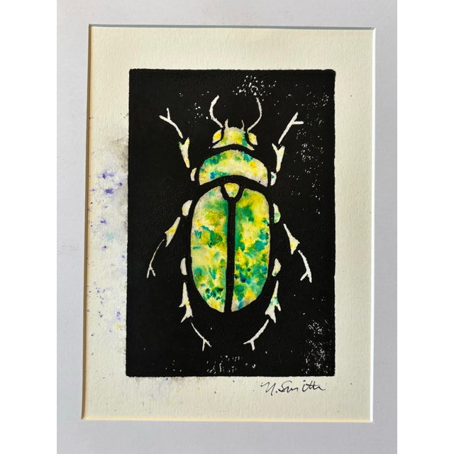 An original hand-carved block linocut featuring a detailed beetle motif, individually printed with black ink and finished...