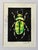 An original hand-carved block linocut featuring a detailed beetle motif, individually printed with black ink and finished...