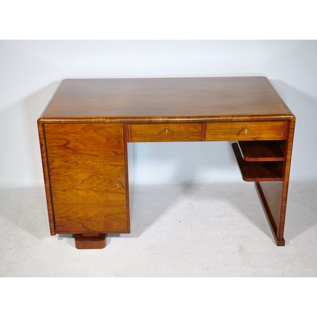Art Deco walnut desk, 1920s. A simple, minimalist design with softly rounded edges and a striking walnut grain. Features...