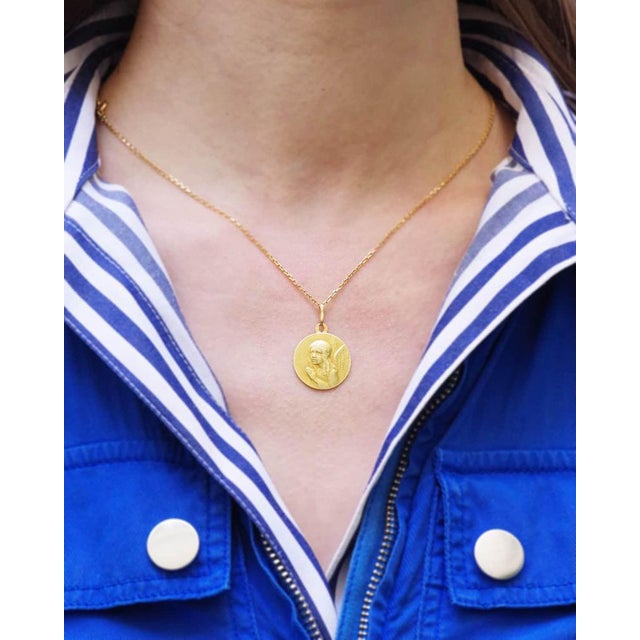 Angel religious pendant in 18 karat gold. Antique medal decorated with a praying angel. The reverse of the medal bears the...