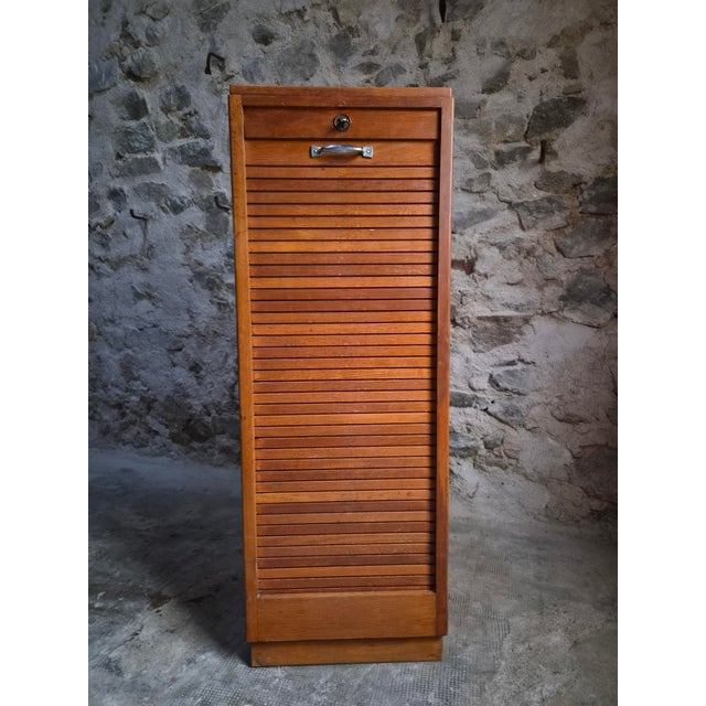 This vintage oak roll top cabinet was made in France during the 1960s–1970s. Originally used in an office, it is now well...