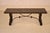 1920's Continental walnut bench in the Spanish Revival style. The top is lovely and is covered in hand painted canvas,...