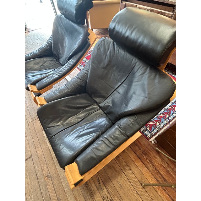 Stylish Swedish midcentury modern lounge chairs in supple black leather and contrasting beechwood bentwood frame, designed...