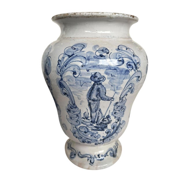 A character rich Italian pottery vessel, hand-painted in cobalt blue on a creamy white ground. The decoration features a...