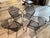 set of four vintage mid-century modern black wrought iron patio dining chairs. Featuring a highly sought-after barrel-back...