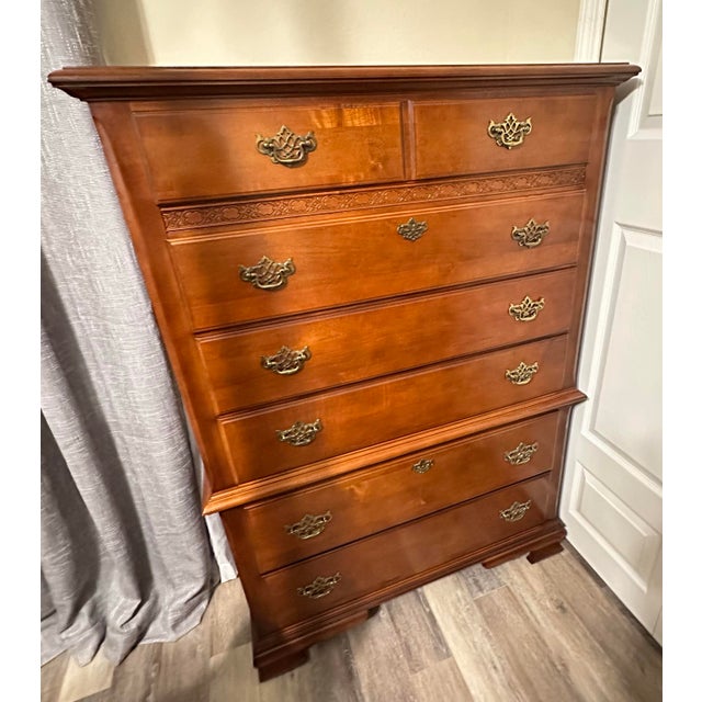 Later 20th Century Stanley Furniture “Open Home” highboy dresser. Warm wood finish with a decorative carved frieze detail...