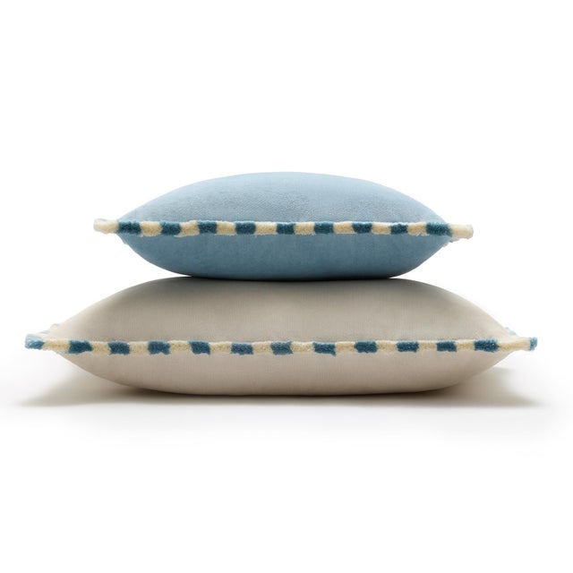 A bold yet refined accent, this cushion is crafted in rich light blue velvet, enhanced by a distinctive striped fringe in...