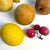 A richly colored collection of 10 vintage decorative stone fruits, assembled as a tabletop still life. The set includes a...