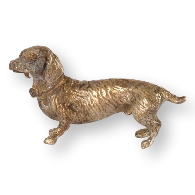Charming miniature Vienna dachshund cast in solid bronze with a polished golden finish. Austrian-made with crisp detailing...