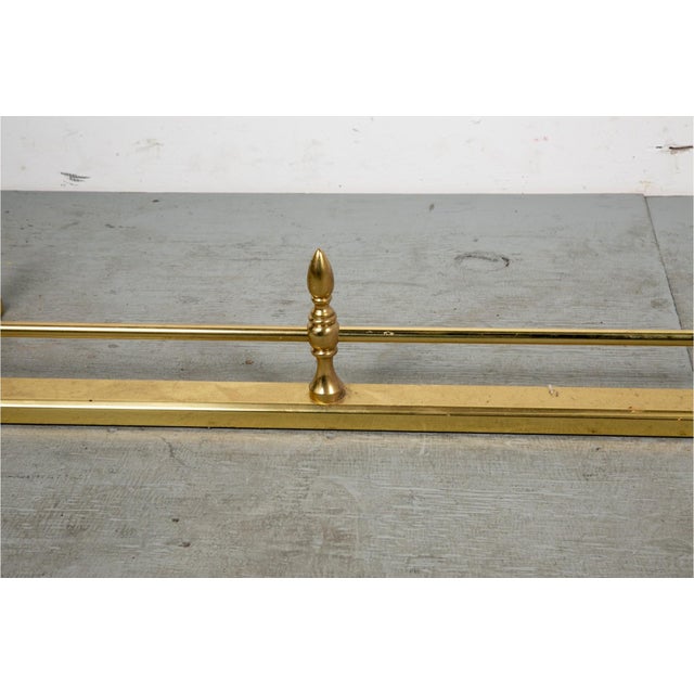 A long Georgian style brass, low and rectangular fireplace fender with a flat brass base rail, raised horizontal bar...