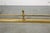 A long Georgian style brass, low and rectangular fireplace fender with a flat brass base rail, raised horizontal bar...