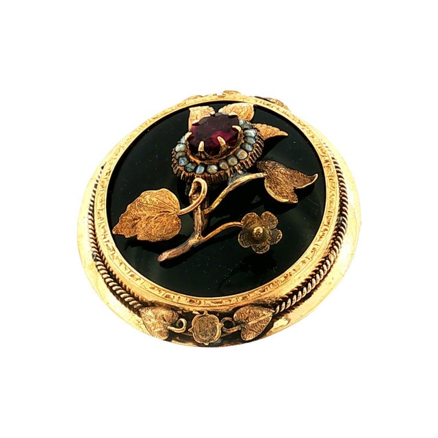 A captivating Grand Period Victorian brooch featuring a floral design on a black onyx background. The center flower is an...