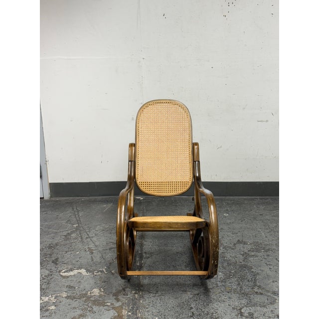 Design Plus Gallery presents a Thonet Style Bentwood Rocking Chair. This rocker has steam bentwood curves adorned with...