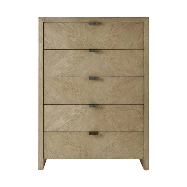 a handsome five-drawer tall bedroom chest made of figured ash in light Dune finish with textured metal pulls in our Ember...