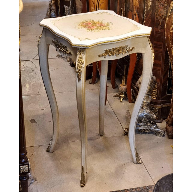 Add a touch of refined French elegance with this charming white accent table featuring a beautifully decorated wood top...