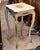 Add a touch of refined French elegance with this charming white accent table featuring a beautifully decorated wood top...