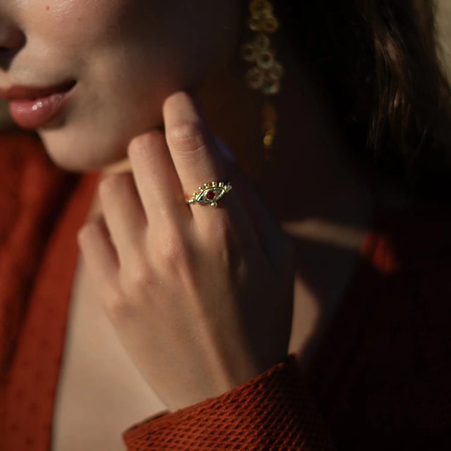 The Mystic Ruby Evil Eye Gold Adjustable Band Ring combines ancient symbolism with bold elegance. Featuring a radiant ruby...