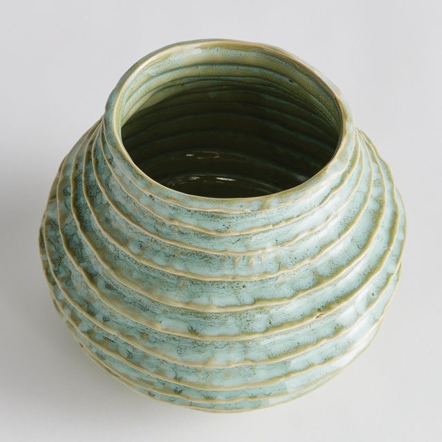 With a reactive glaze and hand finished ribbing detail, this charming sage green vase is a great find. Add a few faux...