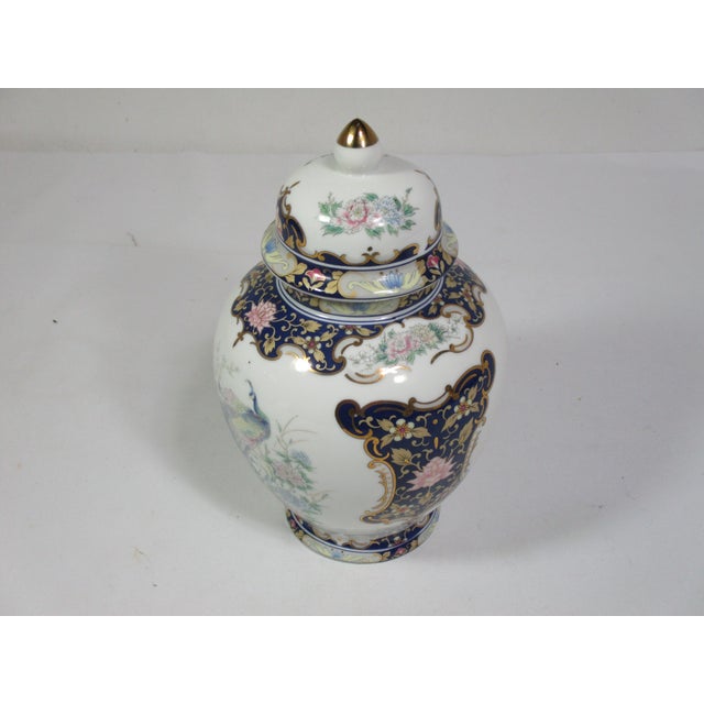 Vintage Asahi porcelain temple jar. It is decorated with peacocks and florals in pastel colors of blue, rose and teal....