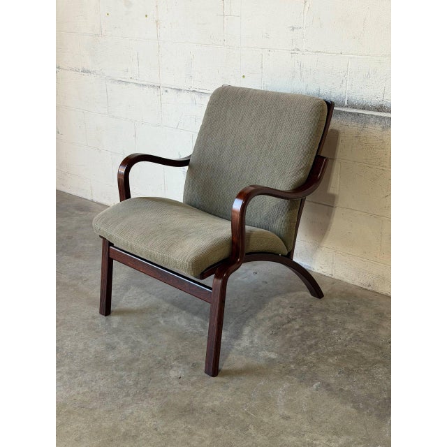 Sculpted bentwood armrests and a gently angled backrest define the relaxed silhouette of this lounge chair. Fluid lines...
