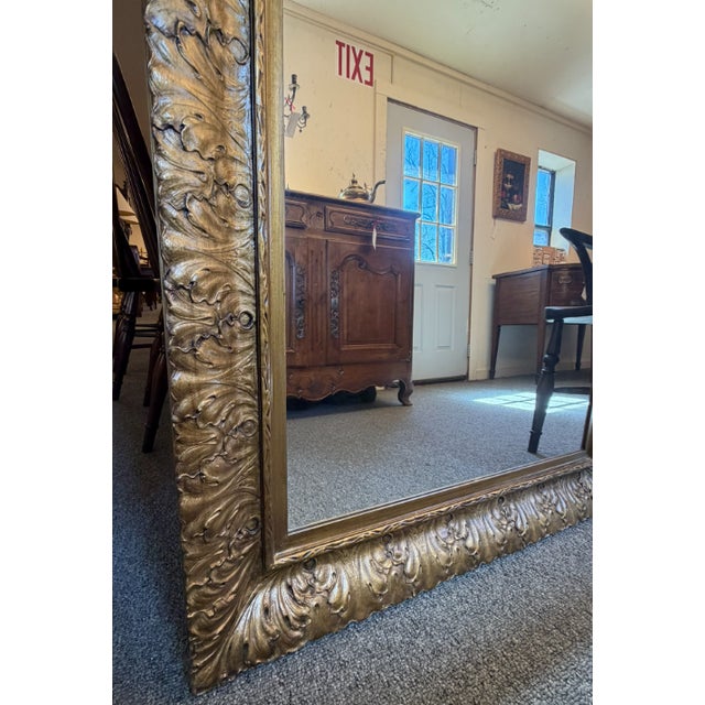 Gilded mirror frame with acanthus leaf carving, late 20th century, circa 1980. A decorative wall mirror frame featuring...