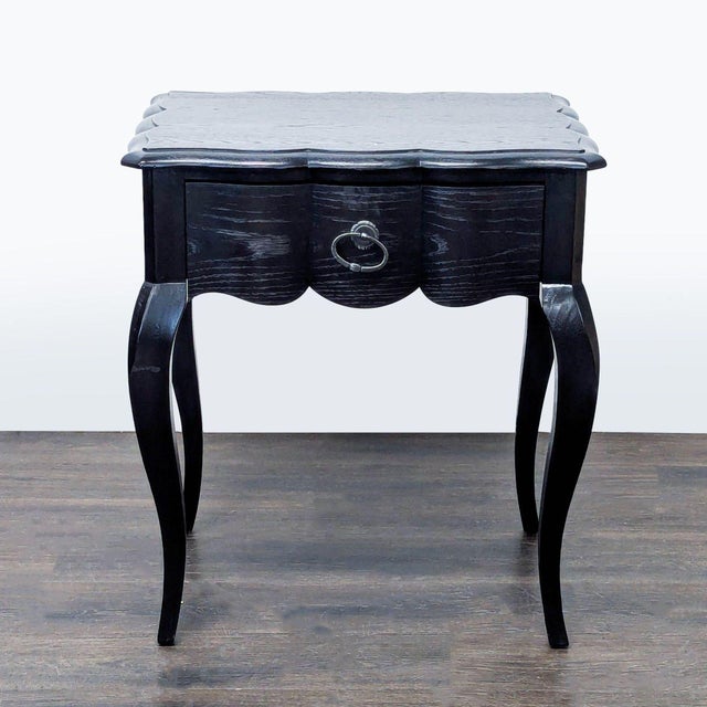 This Bernhardt end table features a classic black finish, elegant, curved legs, and a scalloped top edge. The table...