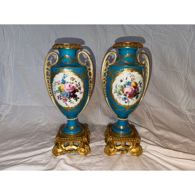 Elegant matched pair of antique French porcelain cabinet vases with turquoise ground and richly gilt decoration. Each vase...