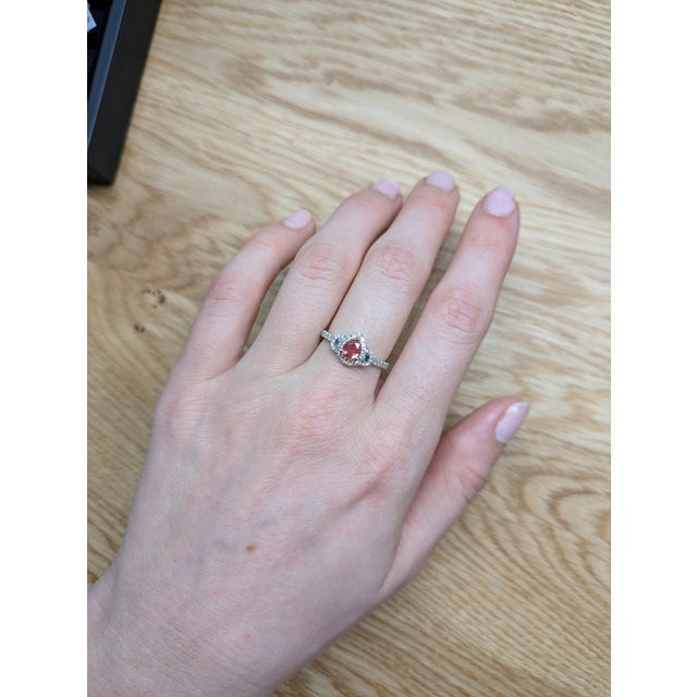 This breathtaking ring features a 0.52ct Padparadscha Sapphire, cut in a beautiful 6x4.5mm pear shape, set in a luxurious...