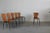 Set of six dining chairs with backs and seats realized in curved veneered plywood and legs in black lacquered metal,...