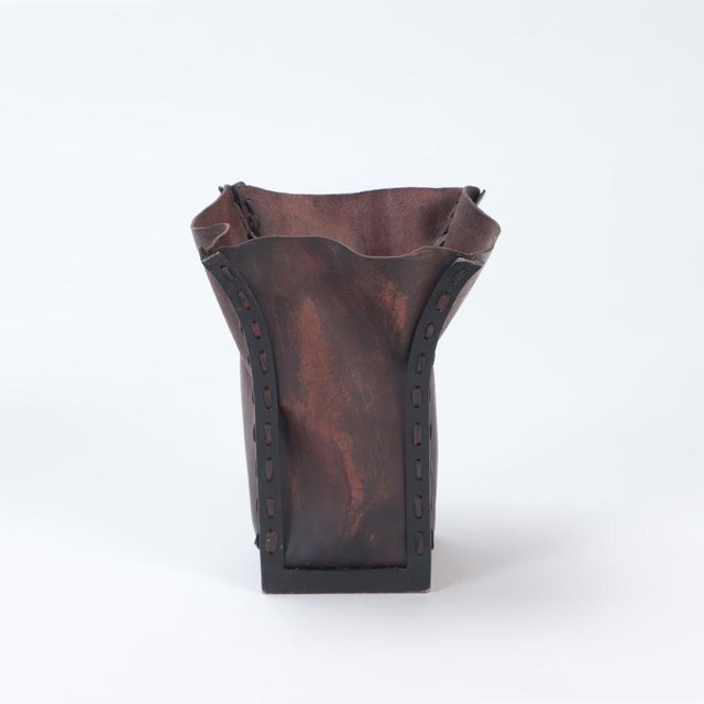 These "paper bag" style leather baskets are held within an iron framework. The juxtaposition of the organically shaped...