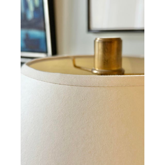 A matching pair of Ralph Lauren Modern table lamps featuring clear cylindrical glass bodies framed by natural brass bases...