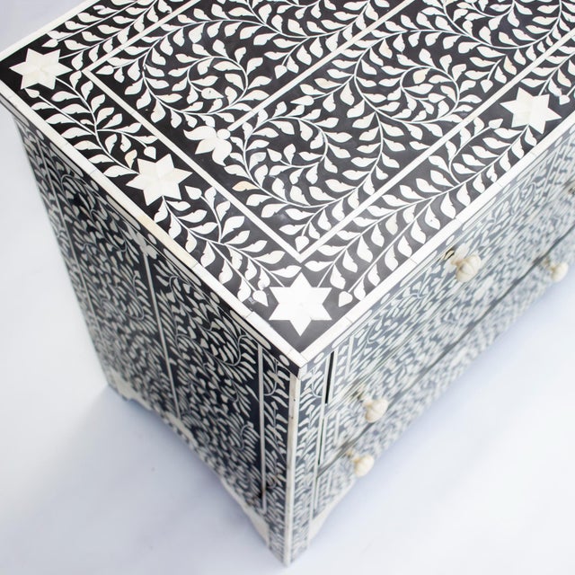 The Arabesque Seven Drawer Dresser combines a wide, rectangular silhouette with intricate bone inlay, contrasting ivory...