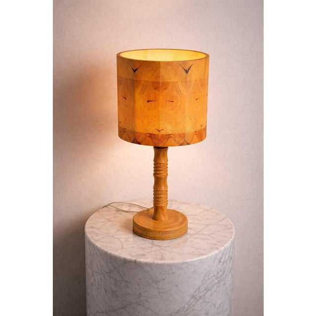 A striking swedish table lamp from the 1960s, masterfully crafted in solid pine and embodying the essence of scandinavian...