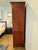 Vintage Baker Furniture mahogany armoire featuring beautifully figured wood panels, refined brass hardware and gold trim,...