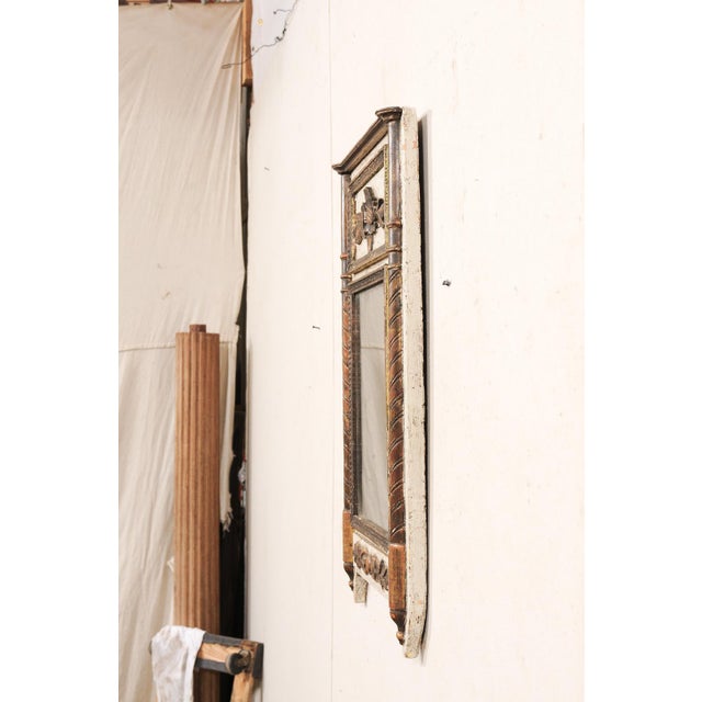 A French Neoclassical period carved-wood mirror, with its original glass and paint, from the early 19th century. This...