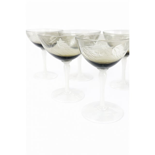 An elegant and atmospheric set of six Art Deco champagne coupes featuring softly smoked bowls, delicate etched detailing,...