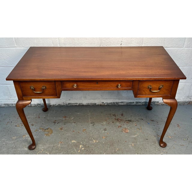 Sophisticated writing desk crafted in warm walnut, showcasing a streamlined form and elegant proportions. Designed with...