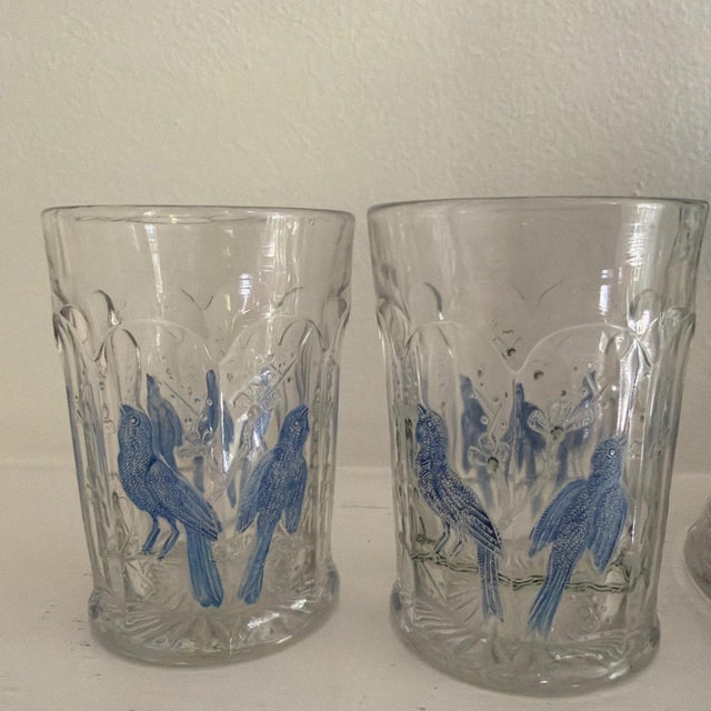 A beautifully hand-painted water or wine pitcher and four matching glasses with flowers and birds.