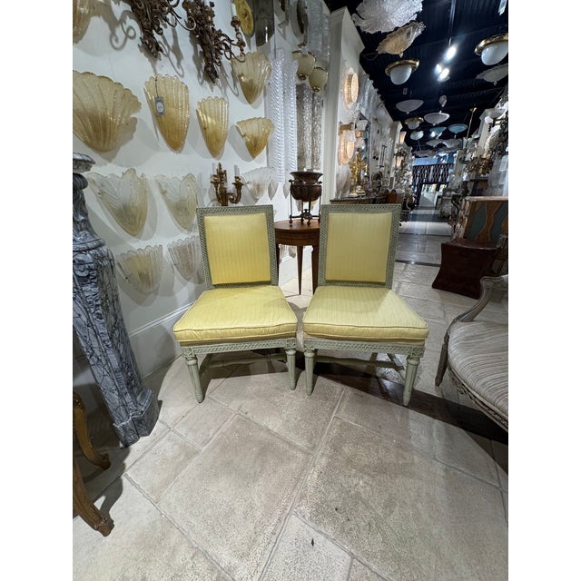 A pair of 19th‑century French Louis XVI side chairs typically means carved, neoclassical, straight‑lined chairs with...