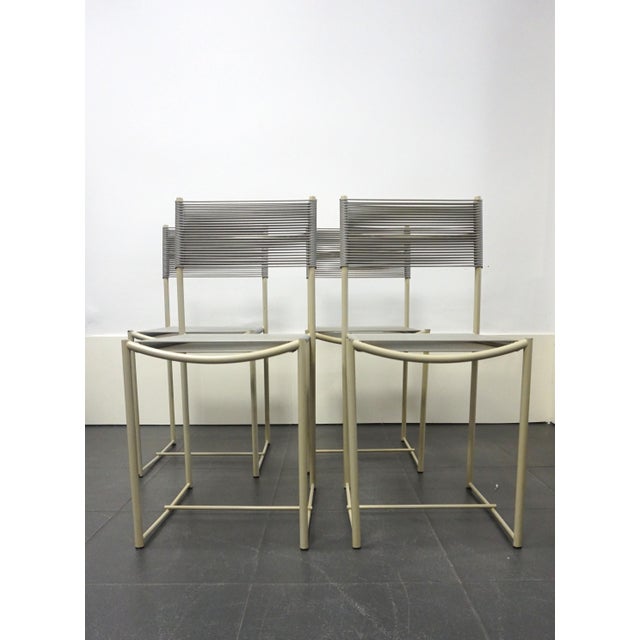 Set of four Spaghetti chairs with gray lacquered steel frames and seats and backs woven with PVC thread. The "Spaghetti"...