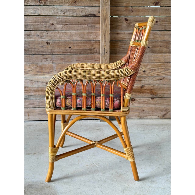 Beautiful vintage French wicker and rattan armchair featuring intricate woven details, arched spindle sides, and warm...